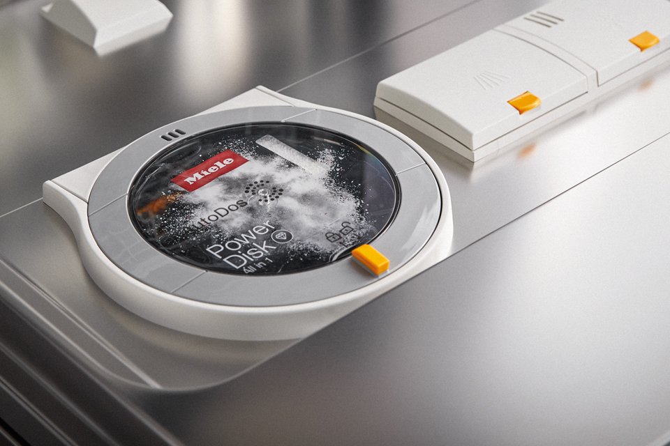 Close up shot of Miele AutoDos cartridge being loaded into Miele dishwasher door.